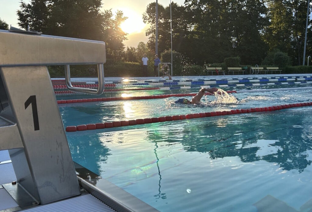 Schwimmer im Aussenbecken des Bibertbades bei Sonnenuntergang